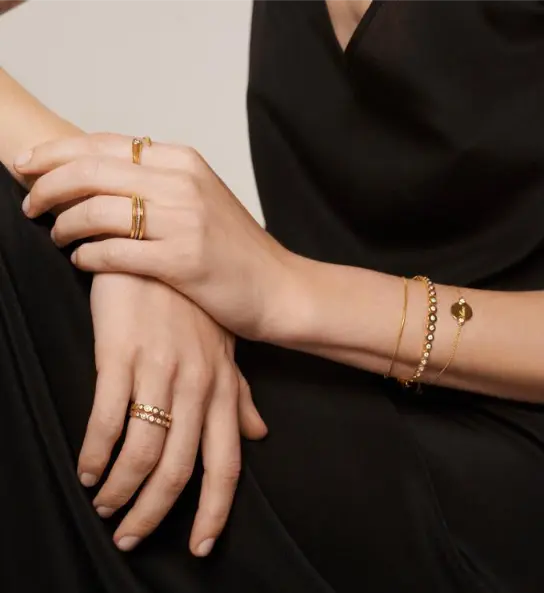 Model hands wearing curated 14K gold-plated ring and bracelet stacks from For you & me SIGNATURE