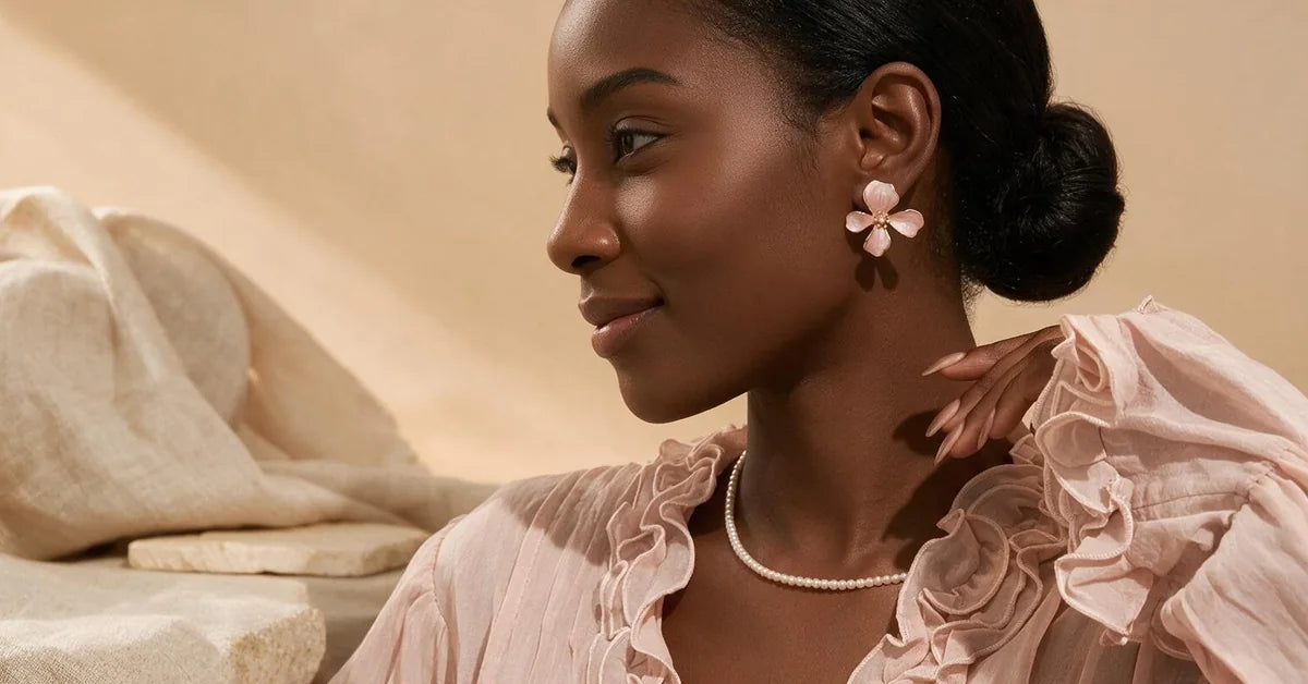Gifts for her: woman wearing pink enamel cherry blossom stud earrings with a simulated pearl centre
