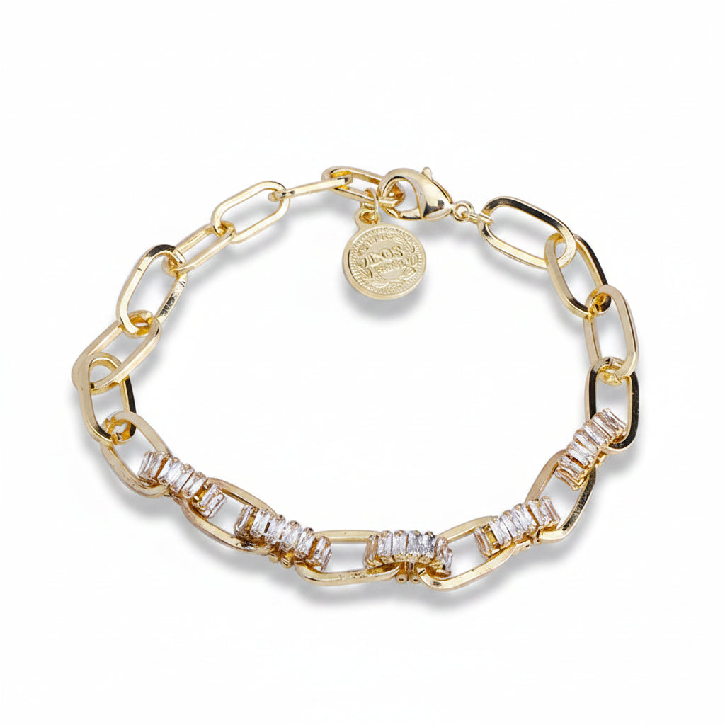 Gold plated copper paperclip chain bracelet with baguette zirconia-paved oval links, lobster clasp and engraved coin charm pendant, coiled on white background with soft drop shadow

