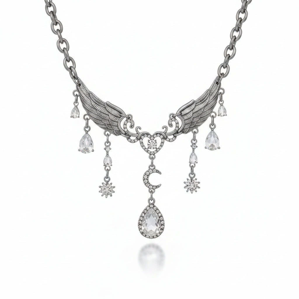 Gothic gunmetal silver-tone alloy angel wing bib necklace with detailed feather-engraved double wings, rhinestone-set heart centerpiece with round white crystal, crescent moon connector and large pear-shaped white crystal halo drop pendant; four pear-shaped and starburst white crystal side drops; gunmetal oval link chain; isolated on white background with soft drop shadow

