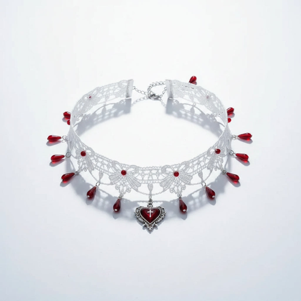 Gothic white lace floral filigree wide choker necklace with multiple red teardrop glass bead drops along bottom edge and silver gothic filigree heart pendant with deep red enamel and white cross, lobster clasp and silver extender chain visible, isolated on white background with directional shadow