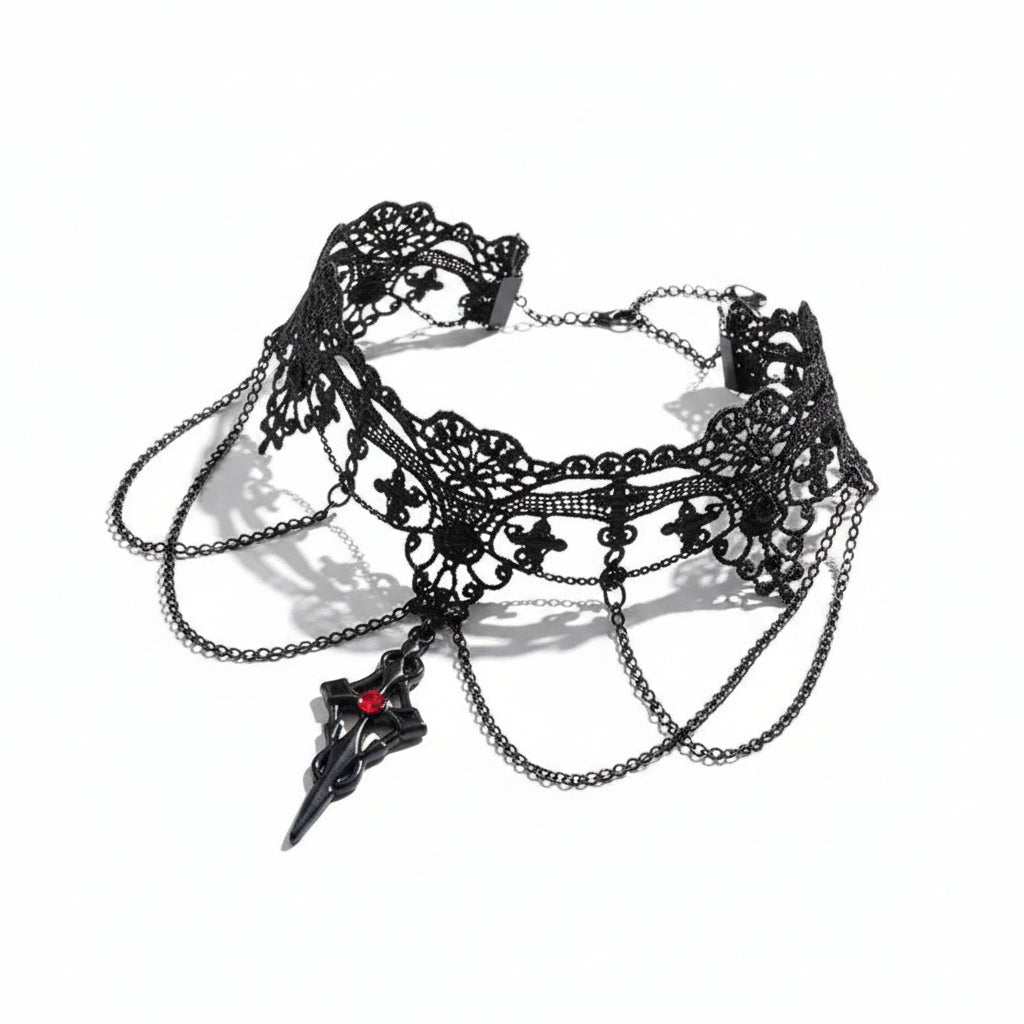 Gothic black lace fleur-de-lis filigree wide choker necklace with three draped gunmetal chains and black dagger spike pendant set with red crystal, magnetic clasp and extender chain visible, isolated on white background with directional shadow