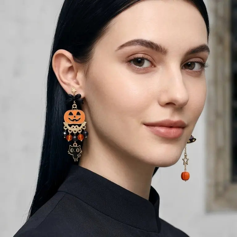 Woman with light skin tone and straight black hair smiling and wearing Halloween asymmetric pumpkin cat and witch hat stud earrings — left ear with orange jack-o-lantern, crystal bead drops and black cat charm; right ear with black bow, witch hat pendant and orange bead drop — black turtleneck top, light grey indoor background with stone pillar, AI-generated model image

