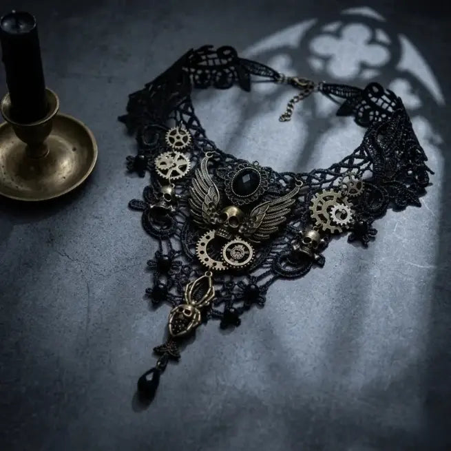 Steampunk gothic black lace bib choker necklace with antique bronze winged skull, gear charms, spider skull drop and black teardrop crystal pendant, displayed on dark blue-grey stone surface with antique bronze candlestick holder, dramatic gothic quatrefoil window shadow projection, AI-generated image
